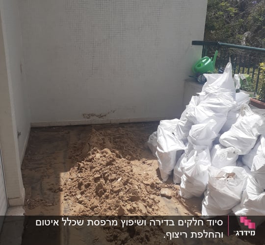 שקי פסולת בנייה וחול על רצפה חשופה